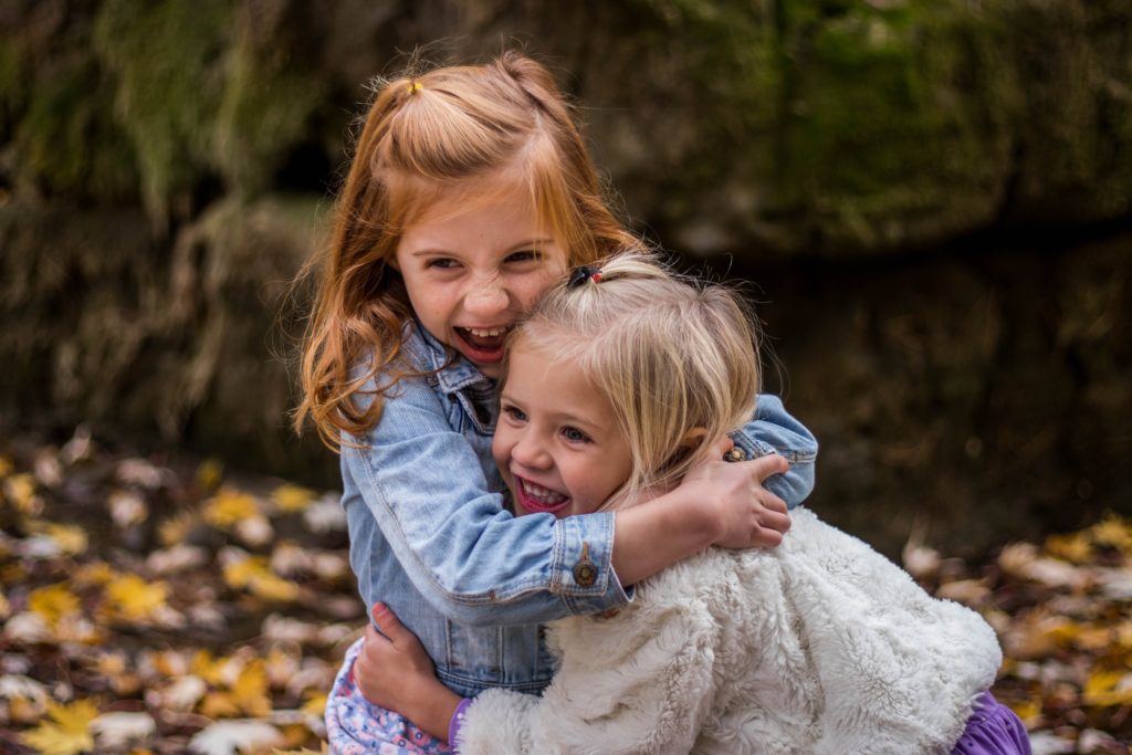 little girls hugging outdoors