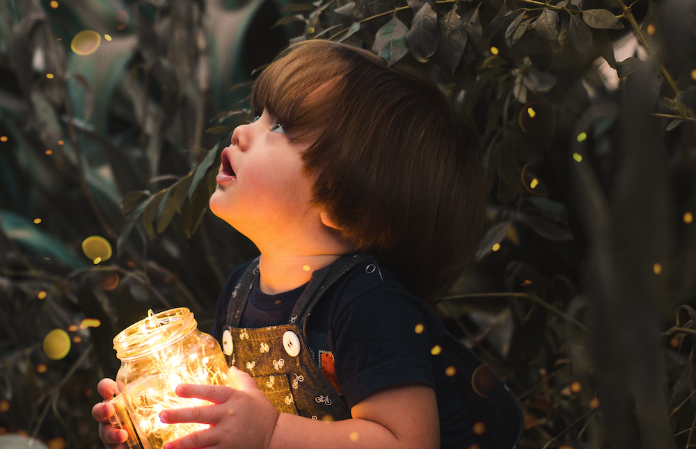 Child holding jar full of lights