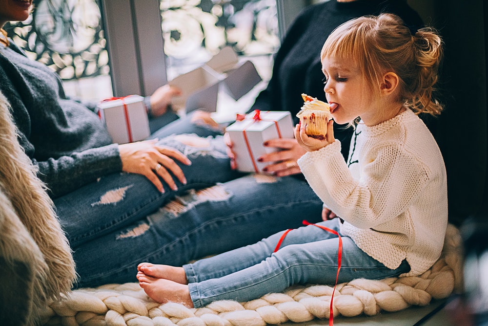 Girl eating a cupcake surrounded by cookies