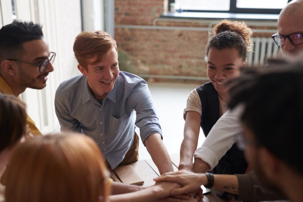 Group of teenagers with their hands all touching