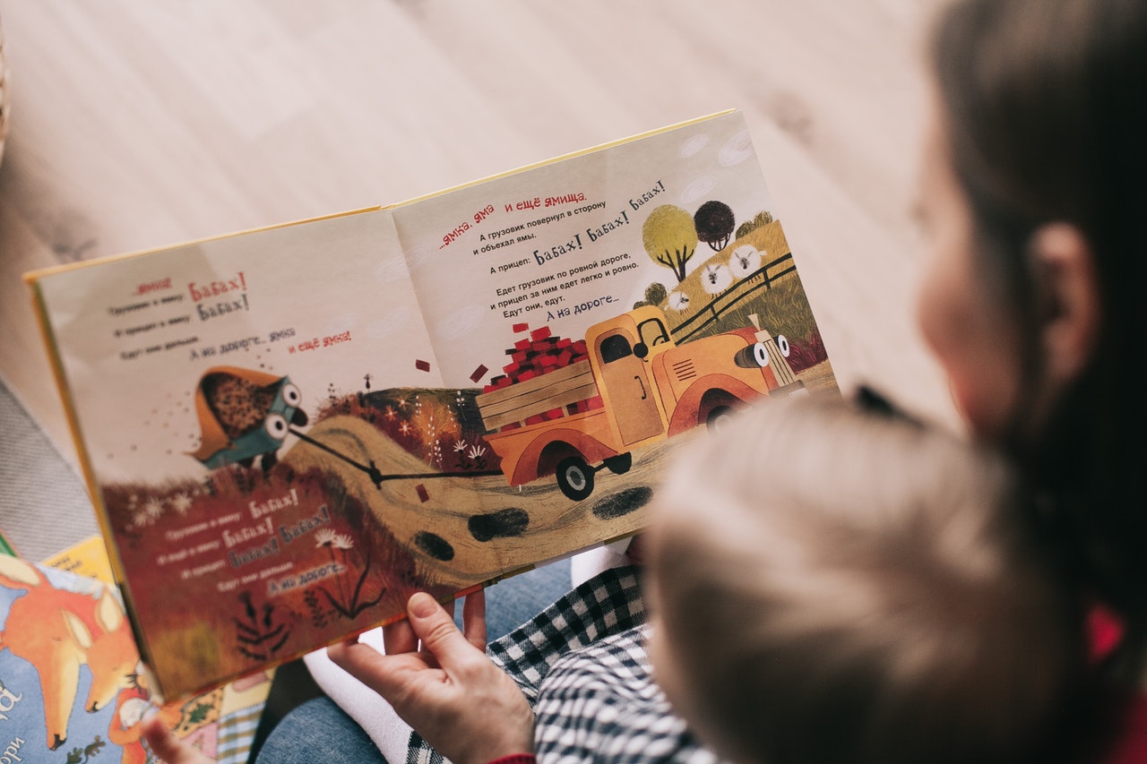 Woman reading a kid's book to her son