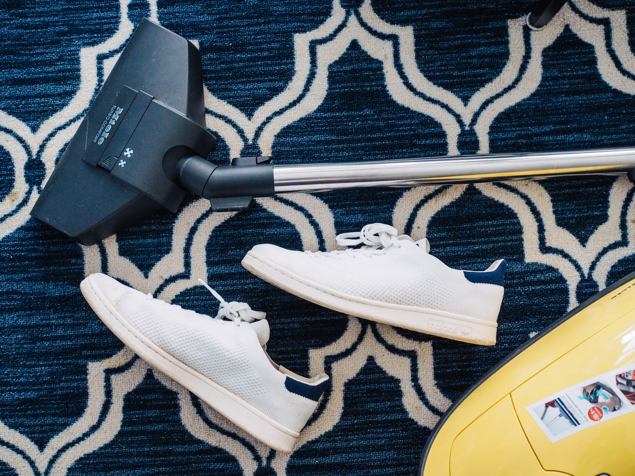 Vacuum and shows laying on a patterned rug