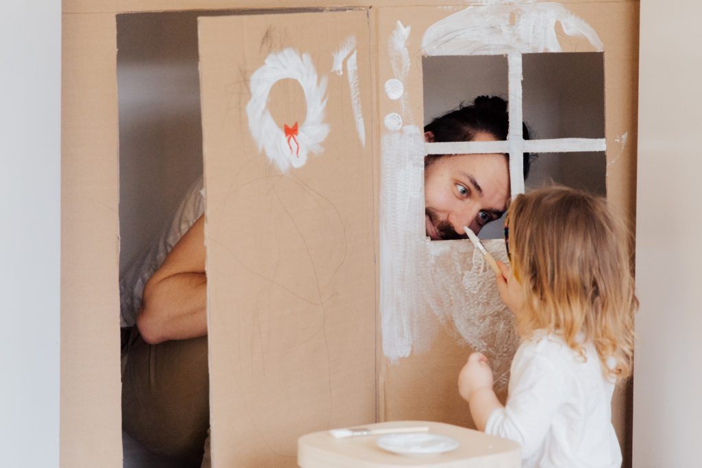 Girl painting a cardboard house