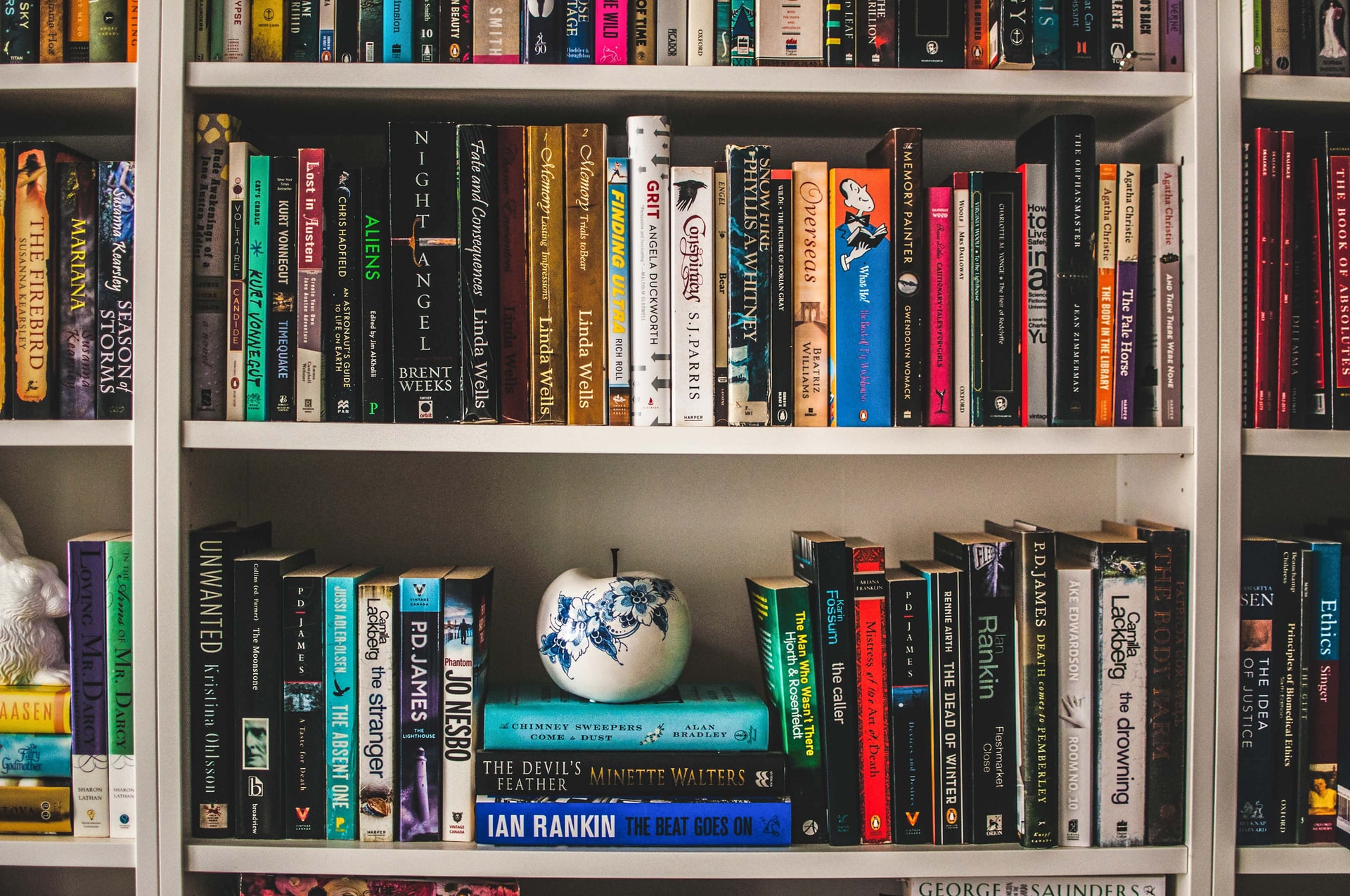 A pot and books on a bookshelf