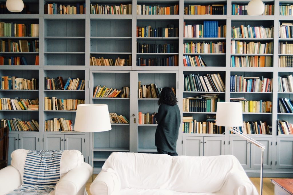 Girl standing in front of a wall of books