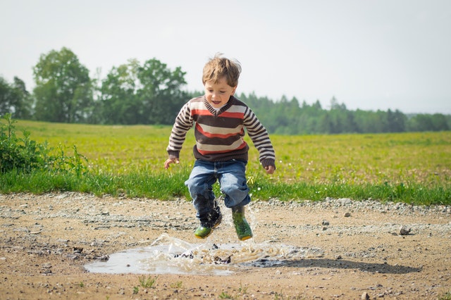 Boy playing in a puddle