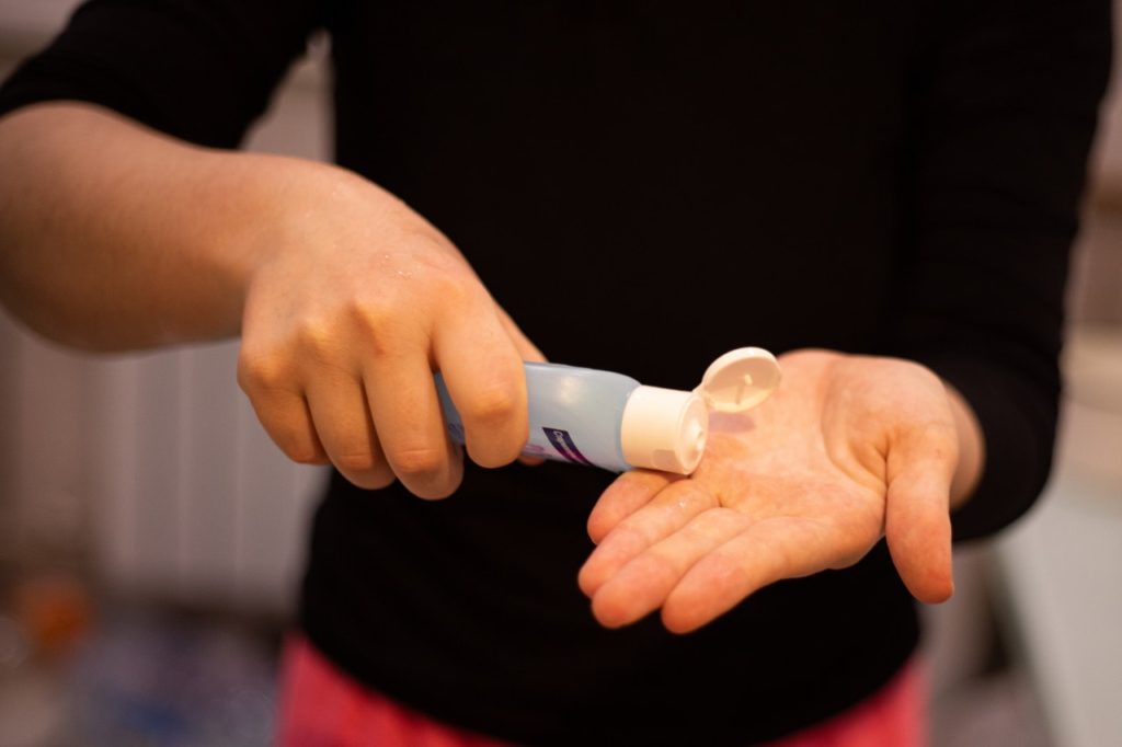 Person squeezing hand sanitizer into their hand