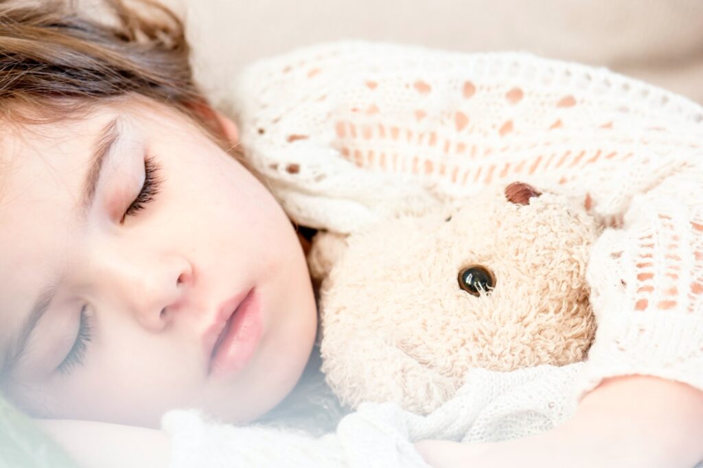 Girl sleeping with a teddy bear