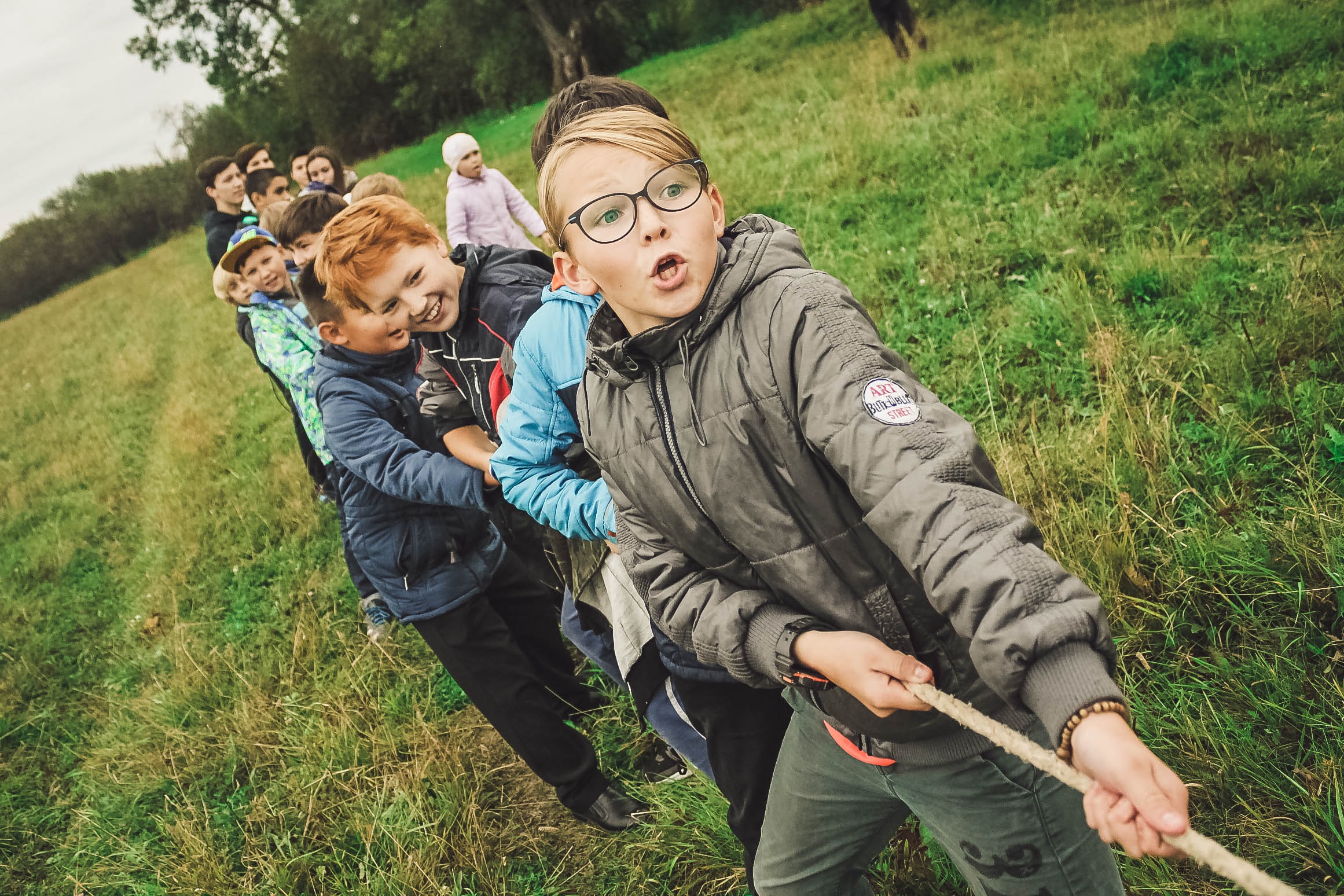 Group of kids playing tug of war in colder weather