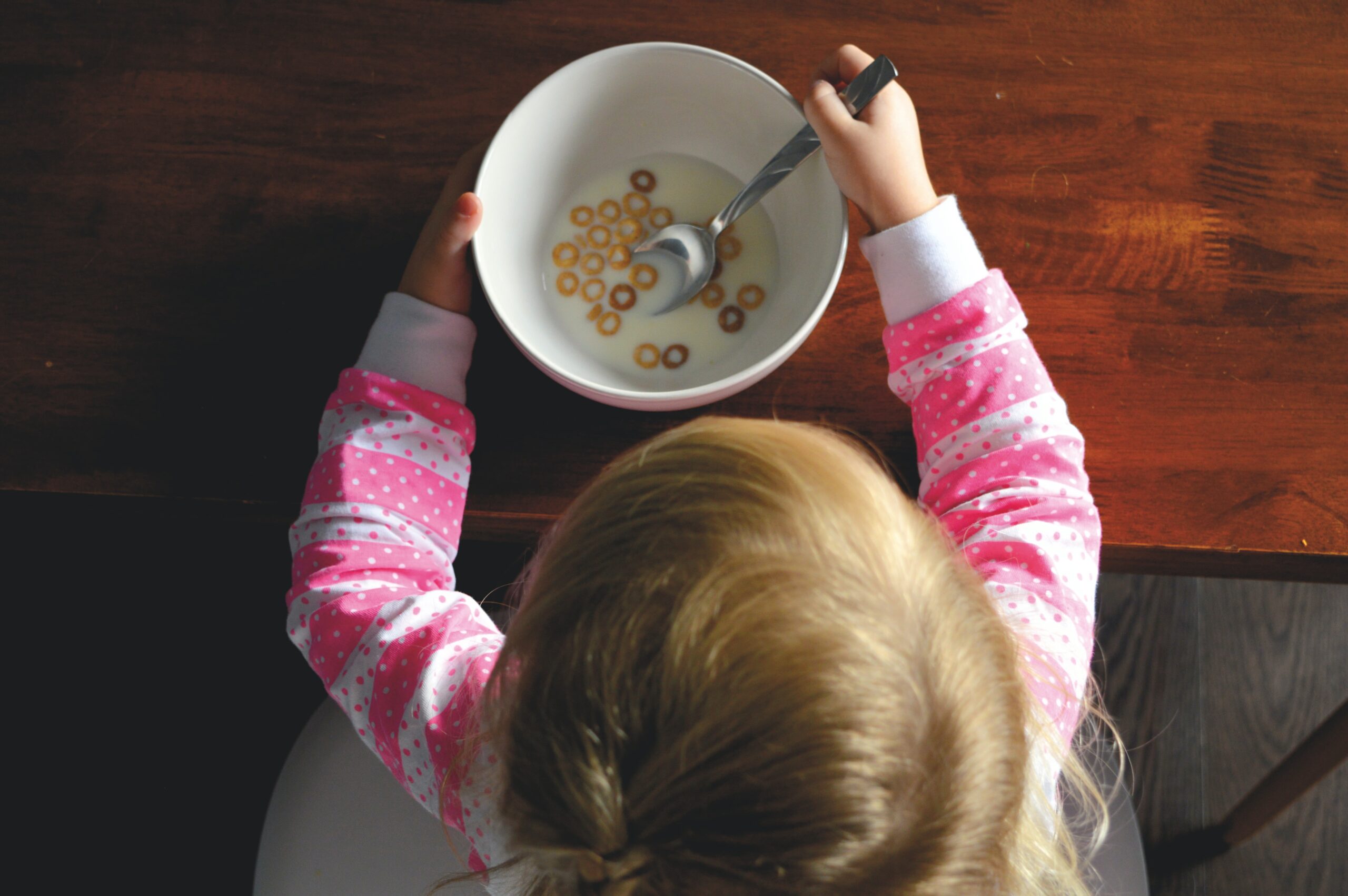 Child finishing bowl of cereal overhead view