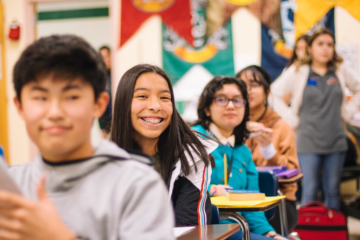 Row of older children smiling in class